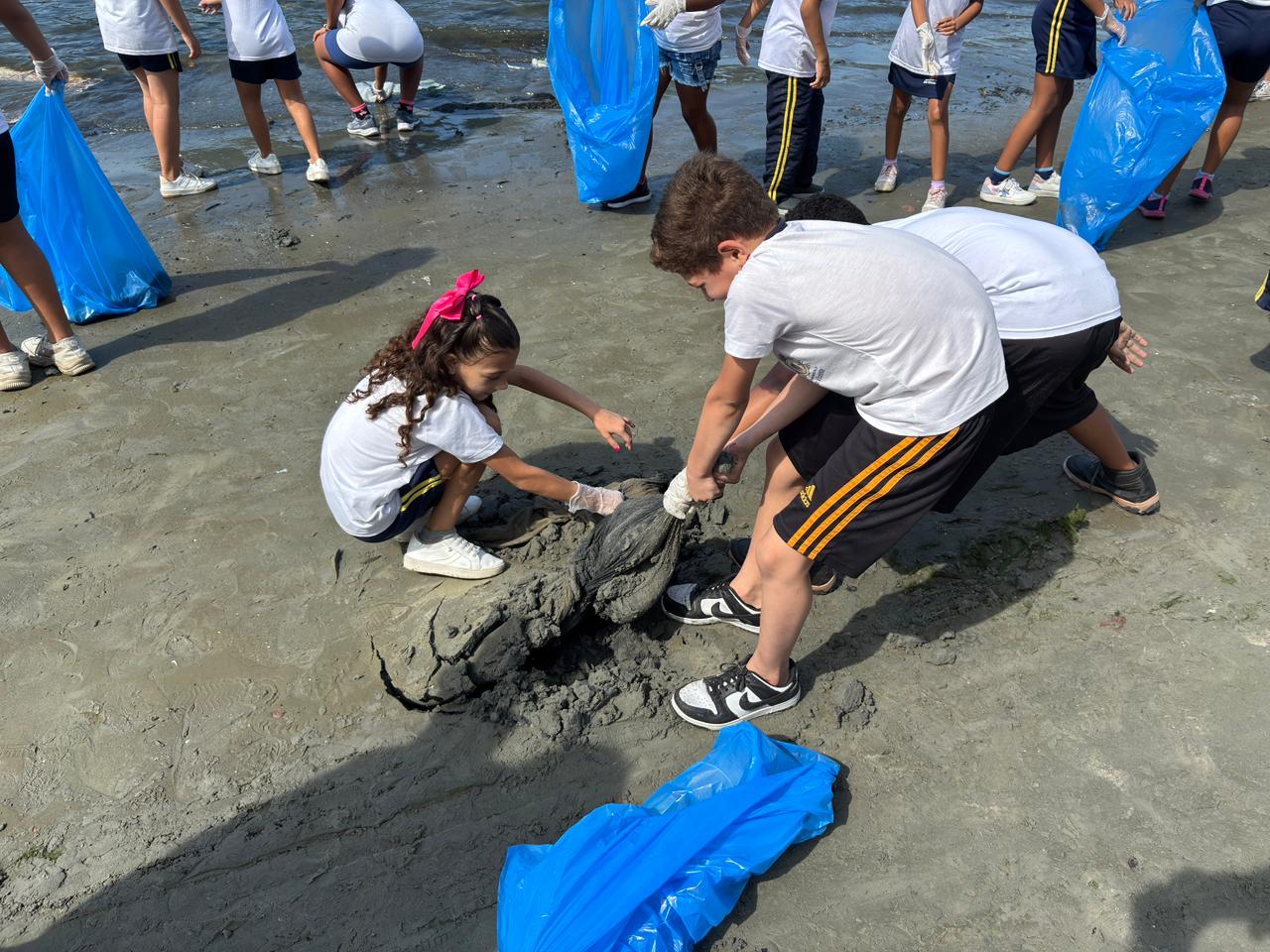 Alunos de escola no Parque Bitaru participam de abraço ecológico e mutirão de limpeza na Praia do Guamyum